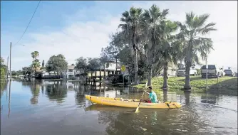  ?? BRETT COOMER / HOUSTON CHRONICLE VIA AP ?? Martin Almanza paddles a canoe through some street flooding following landfall of Hurricane Laura on Thursday in Galveston, Texas.