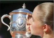  ?? MICHEL EULER — THE ASSOCIATED PRESS ?? Latvia’s Jelena Ostapenko kisses the cup after defeating Romania’s Simona Halep in their final match of the French Open tennis tournament at the Roland Garros stadium, Saturday in Paris. Ostapenko won 4-6, 6-4, 6-3.