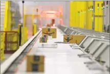  ?? Melissa Phillip / Houston Chronicle ?? Packages move through the shipping sorter at an Amazon facility in Houston.