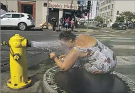  ?? Jae C. Hong Associated Press ?? STEPHANIE WILLIAMS cools off in downtown Los Angeles. Across the nation, extreme heat kills more people each year than hurricanes, wildfires and floods.