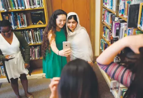  ??  ?? Cherokee Ronolo-Valdez, 17, a senior at Denver South High School, takes a selfie with Nobel Peace Prize winner Malala Yousafzai on Friday. Yousafzai made a surprise appearance at the school, which has several refugees enrolled. RJ Sangosti, The Denver...