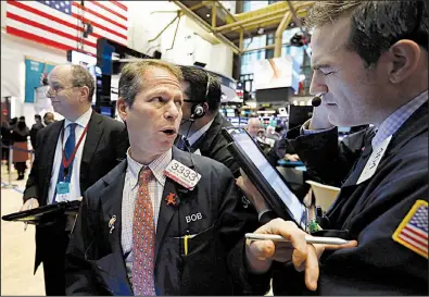  ?? AP/RICHARD DREW ?? Robert Charmak (center) works with fellow traders on the floor of the New York Stock Exchange on Wednesday.