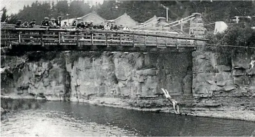  ?? PHOTO COURTESY OF DON HESSELIN ?? Euan Cameron dives from the Mataura bridge in 1913.