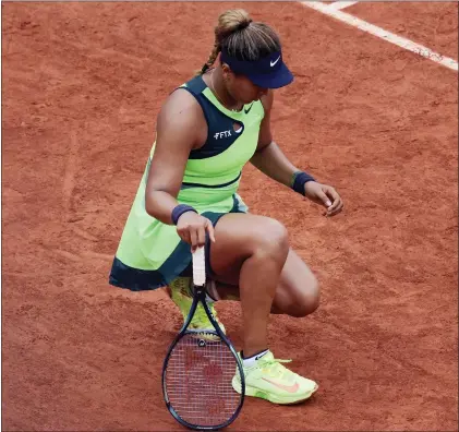  ?? CHRISTOPHE ENA — THE ASSOCIATED PRESS ?? Naomi Osaka stretches her left foot during her first round match against Amanda Anisimova at the French Open tennis tournament in Roland Garros Stadium in Paris, France on Monday.