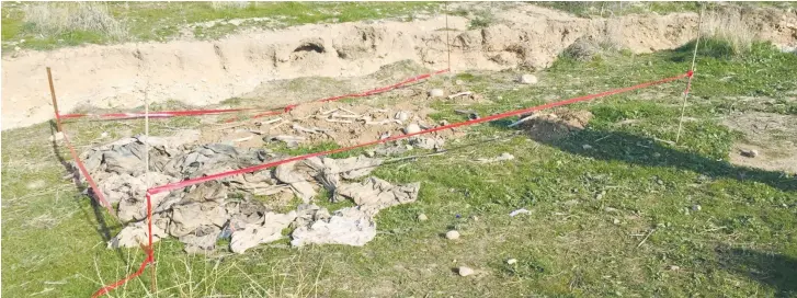  ??  ?? A MASS GRAVE of Yazidis killed by ISIS in 2014 is seen in Sinjar, Iraq, a year later.