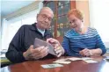  ?? AP ?? Paul Grisham and his wife, Carole Salazar, look at items found inside the wallet he lost in Antarctica in 1968.