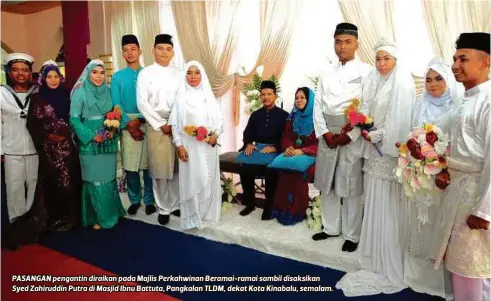  ??  ?? PASANGAN pengantin diraikan pada Majlis Perkahwina­n Beramai-ramai sambil disaksikan Syed Zahiruddin Putra di Masjid Ibnu Battuta, Pangkalan TLDM, dekat Kota Kinabalu, semalam.