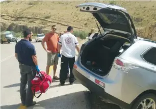  ?? (MDA) ?? EMERGENCY MEDICAL personnel work near a car after a crash in the Jordan Valley in April.