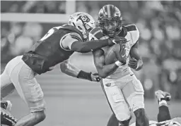  ?? DAVID ZALUBOWSKI/AP ?? Oregon State’s B.J. Baylor, right, drives for a first down as Colorado’s Mark Perry reaches for a stop during their Nov. 6 game in Boulder, Colo.