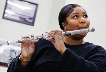  ?? — Shawn Miller/Library of Congress photos ?? Lizzo plays a flute that belonged to President James Madison at the Library of Congress.