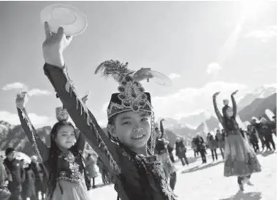  ??  ?? Children in ethnic dresses dance to celebrate Spring Festival last week in Lake Tianchi tourist area in the Xinjiang Uygur Autonomous Region. — Xinhua