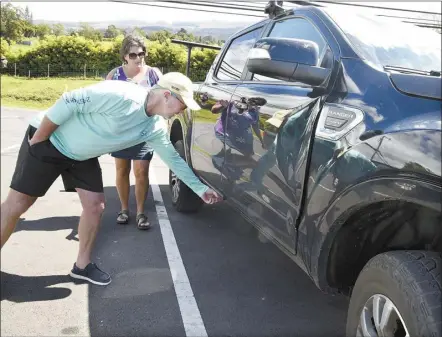  ?? The Maui News / MATTHEW THAYER photos ?? Sydney Sparkman inspects damage to his 2021 Ford Ranger Friday afternoon along with wife Alysha Nichols-Sparkman.