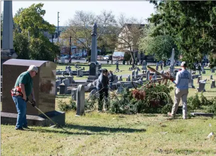  ?? PHOTO BY SANDI YANISKO/THE HILL SCHOOL ?? Volunteers help clear overgrowth from a grave “cradle” at Edgewood Cemetery in Pottstown during the second annual cleanup event.