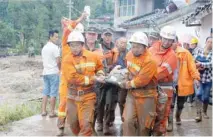  ?? — Reuters ?? Rescue workers carry an injured villager at the site of a landslide that occurred in Gengdi village, Sichuan province, China, on Tuesday.