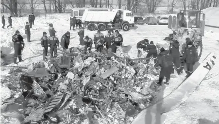  ??  ?? Emergency personnel collect wreckage Tuesday from Sunday’s plane crash outside of Moscow.