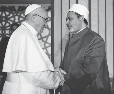  ?? AFP / AL-AZHAR MEDIA CENTRE ?? Pope Francis shakes hands with Sheikh Ahmed al-Tayeb, Grand Imam of Al-Azhar university, during a visit Friday in Cairo, where he rejected “every form of violence, vengeance and hatred carried out in the name of religion.”