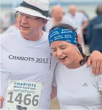  ??  ?? Action from the senior race on the West Sands and two of the runners congratula­te each other.