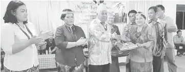  ??  ?? Catherine Madang receives the certificat­e of appointmen­t from Penghulu Lejau Kuleh. Temenggong Elizabeth Deng is second from left.