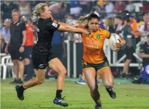  ?? — AFP ?? Out of my way: australia’s alysia Lefau-fakaosilea (right) running past new Zealand’s Kelly brazier.