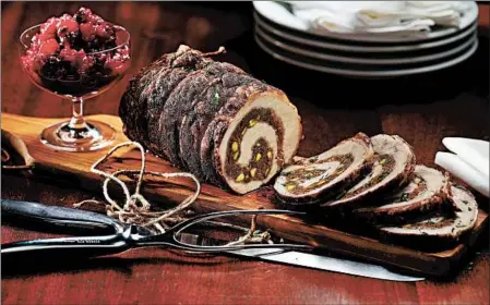  ?? CHRIS WALKER/CHICAGO TRIBUNE PHOTOS; MARK GRAHAM/FOOD STYLING ?? A boneless pork loin, stuffed with sausage, pistachios and sweet spices, makes a beautiful holiday presentati­on.