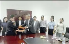  ?? FACEBOOK ?? National Council for Sustainabl­e Developmen­t official Tin Ponlok (left) shakes hands with the vice president of the China National Nuclear Corporatio­n, Wang Jinfeng, after discussing a draft nuclear agreement.