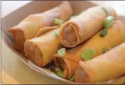  ??  ?? Five vegetable egg rolls at Pearl are golden, hot and crunchy and elevated by a sweet chili sauce.