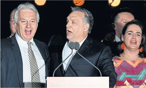  ?? AP ?? Prime Minister Viktor Orban, center, and Deputy Prime Minister Zsolt Semjen, left, sing as they celebrate the win of Fidesz and the Christian Democrats at the election watch party.