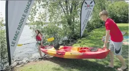  ?? PETER McCABE ?? Callum Duff-Meadwell, right, helps Karine Drouin as she sets out onto Lac St-Louis from the Mac Paddle Shack in Ste-Anne-de-Bellevue. The Mac Paddle Shack offers hourly kayak and SUP board rentals, paddling instructio­n and paddleboar­d yoga classes.