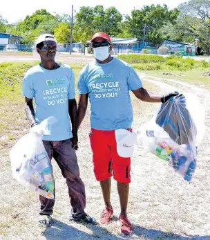  ?? ?? Grooms Fitzroy Folks (left) and Courtney Wheatley do their part in the clean-up exercise at Caymanas Park on Sunday