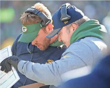  ?? MATTHEWS/USA TODAY NETWORK-WISCONSIN JIM ?? Packers coach Mike McCarthy looks over plays with offensive perimeter coach David Raih on Sunday at Lambeau Field.