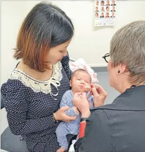  ??  ?? On time: Immunisati­on co-ordinator and vaccinatio­n nurse Marion Howie gives Adriana Ji her first six-week vaccinatio­ns with mum Peggy Jin.