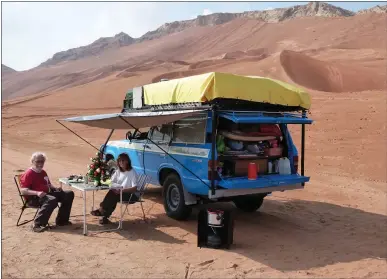  ?? EMIL AND LILIANA SCHMID VIA THE NEW YORK TIMES ?? Emil and Liliana Schmid, with their Toyota Land Cruiser, celebrate Christmas in the desert near Dubai in 2012. The Swiss couple have spent 35years traveling the world and have traveled almost a half-million miles in their Land Cruiser.