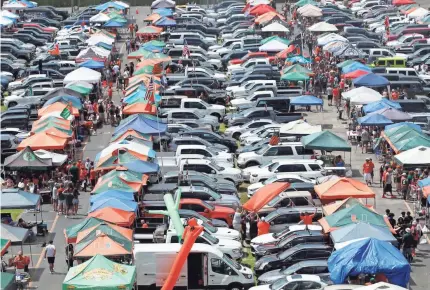  ?? WILFREDO LEE/AP ?? University of Miami fans tailgate before a football game last season. The 50-plus public schools in Power Five conference­s have at least $4.1 billion in fiscal-year revenue tied to football, according to a USA TODAY Sports analysis.