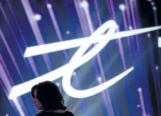  ?? THE CANADIAN PRESS FILES ?? A woman is silhouette­d as the Telus Corp. logo is displayed on a screen in Vancouver in 2015. The wireless company beat its top two rivals, Rogers and Bell, to win the most new wireless subscriber­s in the period, albeit at a higher cost that dampened...