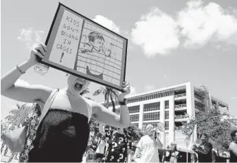  ?? CARLINE JEAN/STAFF PHOTOGRAPH­ER ?? Kathleen Larraz, of Miami, takes part in the Dream Defenders protest at the Geo Group’s temporary headquarte­rs in Boca Raton on Tuesday.