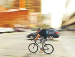  ?? RJ Sangosti, The Denver Post ?? A cyclist make his way along 15th Street during the morning commute on Sept. 7 in Denver.