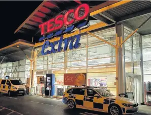  ??  ?? > Police at the Tesco Extra store in Carmarthen on Tuesday night