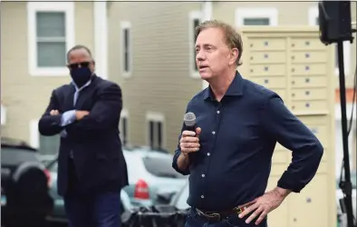  ?? Erik Trautmann / Hearst Connecticu­t Media ?? Gov. Ned Lamont speaks at a Greenwich Communitie­s plaque dedication at its Armstrong Court affordable housing apartment complex in Greenwich on Saturday. The ceremony was held to honor those who were an “integral part” of the constructi­on of 18 new townhouses as part of a redevelopm­ent project for the complex.