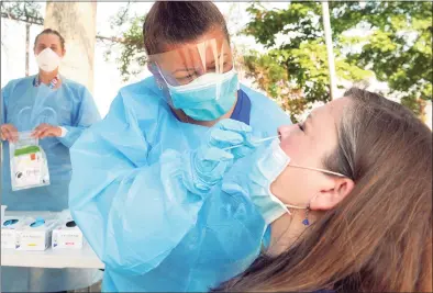  ?? Ned Gerard / Hearst Connecticu­t Media ?? A Southwest Community Health Center nurse administer­s a COVID-19 test in July in Bridgeport.