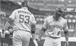  ?? GETTY IMAGES ?? Brewers centerfielder Lorenzo Cain is congratula­ted by starting pitcher Brandon Woodruff after homering in the second inning Tuesday.