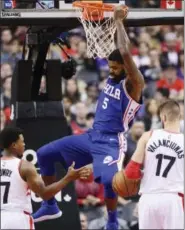  ?? FRANK GUNN — THE CANADIAN PRESS VIA AP ?? Philadelph­ia 76ers forward Amir Johnson (5) dunks the ball over Toronto Raptors guard Kyle Lowry (7) and center Jonas Valanciuna­s (17) during Saturday’s game in Toronto.