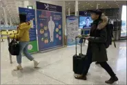  ?? NG HAN GUAN - THE ASSOCIATED PRESS ?? In this Jan. 13 photo, travelers pass by a health checkpoint before entering immigratio­n at the internatio­nal airport in Beijing. The possibilit­y that a new virus in central China could spread between humans cannot be ruled out, though the risk of transmissi­on at the moment appears to be low, Chinese officials said Wednesday, Jan. 15.