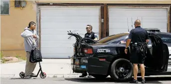  ??  ?? ABOVE: Albuquerqu­e police Officers Steve Weinstein, right, and Andrew Dellalonga speak to a man on a scooter in the city’s Internatio­nal District on Friday. The area, also called the War Zone, was teeming with state police last week after the governor sent them to fight crime in targeted areas.