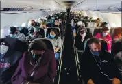  ?? ERIN SCHAFF — THE NEW YORK TIMES ?? Travelers aboard a fully booked Jet Blue flight last month. Americans who are fully vaccinated against COVID-19 can safely travel at home and abroad, as long as they take basic precaution­s, federal health officials announced Friday.