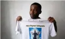  ?? Photograph: Ian Cheibub/Reuters ?? Chadrac Kembilu Nkusu, a cousin of Moïse Kabagambe, shows a T-shirt with a Kabagambe image at a Congolese community center in Rio de Janeiro.