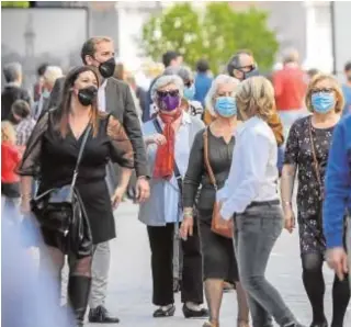  ?? RAÚL DOBLADO ?? Un grupo de personas pasea por una calle de Sevilla capital