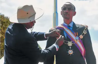  ??  ?? Rwandan president Paul Kagame receiving the Pearl of Africa Medal from Ugandan president Yoweri Museveni, Kapchorwa District, Uganda, 2012