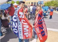  ?? GREG SORBER/JOURNAL ?? Dylan Salazar and Celestial Sena wear Trump banners as they wait for Monday night’s rally to begin.