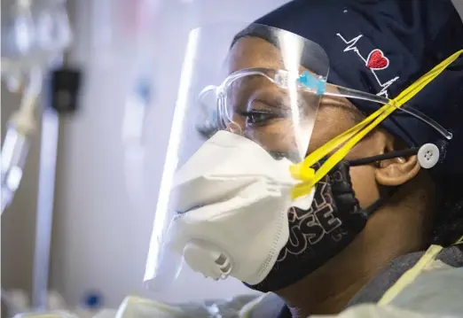  ?? ASHLEE REZIN GARCIA/SUN-TIMES ?? Nurse Jessica Bell administer­s a sedative to a man with COVID-19 in December in the Intensive Care Unit at Roseland Community Hospital.