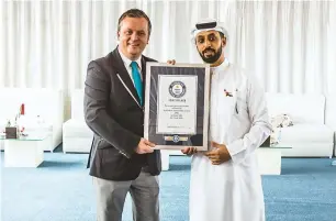  ?? Photos by Neeraj Murali ?? Ahmed bin Sulayem places the last piece of jigsaw puzzle to create the Year of Zayed logo, which claimed the Guinness World Records title for the world’s largest jigsaw puzzle by surface area. Right, Kevin Southam presents the certificat­e of Guinness World Record to Bin Sulayem. —